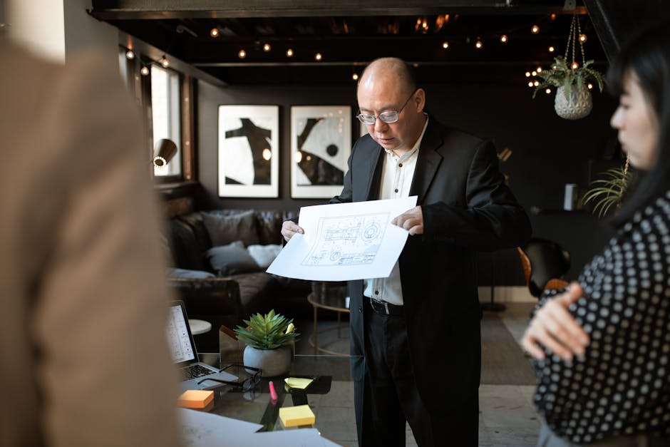 Professional team discussing blueprints in a stylish office setting. Engaged in planning and collaboration.